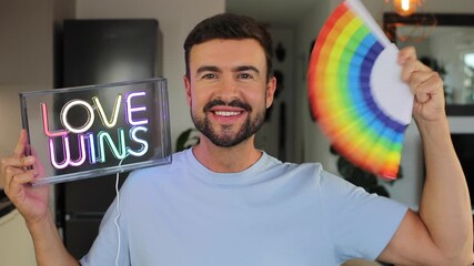 Proud handsome man waving a fan with the rainbow flag - Powered by Adobe