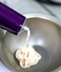A hairdresser squeezes hair dye out of a tube. Coloring and professional hair care. Close-up. Selective focus.