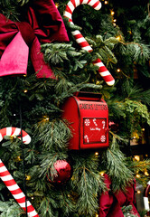 Red mailbox for Santa&rsquo;s letters surrounded by festive pine branches and candy canes &mdash; a magical Christmas corner filled with warmth and holiday spirit. Selective focus.