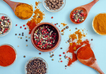 Сolored peppers in bowl on blue background. Texture of food seasonings close-up. Vibe of spices.