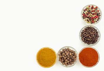 Top view of spice composition in bowls. Colorful Indian and Asian seasonings on white.