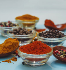 Bright orange paprika in bowl on blue background. Food seasoning texture. Seasonings atmosphere.