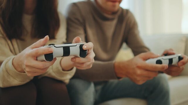 Couple enjoying a video game session in a cozy living room while sitting on a comfortable couch in the afternoon light