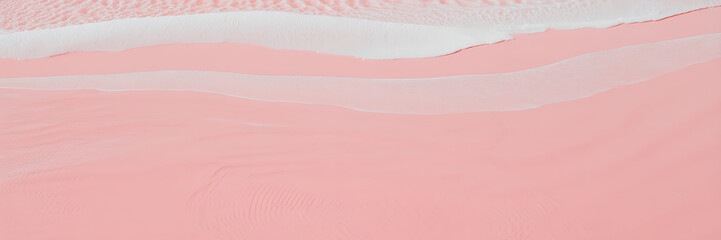 Abstract aerial view of pink sand dunes with white wave patterns