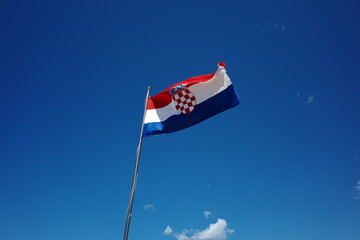Colorful flag waving in the clear blue sky on a sunny day