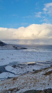 Scenic view of the winter  landscapes at Bunes Beach on a  with the mountains in the background on Lofoten Islands in Norway.

