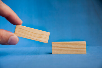 Hand placing wooden block on tower symbolizing strategy, planning, and balance with customizable space for text or ideas.