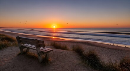 Beautiful beach sunset landscape with wooden bench on sand dune, golden sunlight reflecting on calm sea waves, peaceful evening horizon, nature travel background, serene coastal scenery at twilight