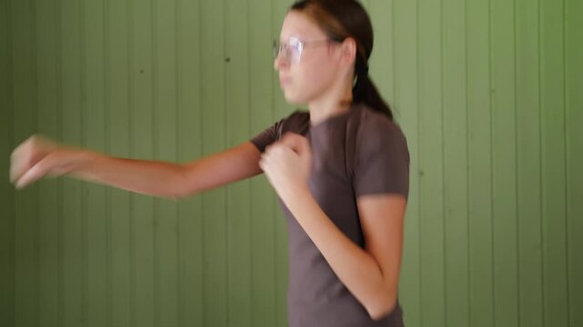 14 years old teenager customized workout, a mix of strength training, flexibility exercises, and cardio at home. Authentic shot. Teen girl exercises with dumbbells. Holistic Health, Mental WellBeing