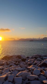 Arctic Winter landscape norwegian sea shore village  with snowy covered mountains peaks  sunset view Lofoten islands, Norway