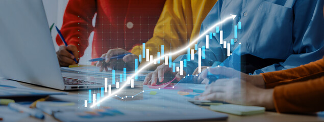 Professionals engage in a productive teamwork session analyzing financial trends and developing strategies using laptops and colorful charts to visualize growth. Axiom