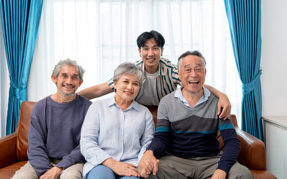asian family group of senior man woman and son smiling sitting together in living room. home caregiver nurse visit retirement patient for health check up recovery process medical service - Powered by Adobe