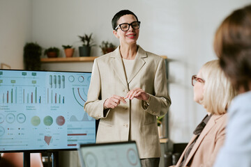 Caucasian middle aged woman presenting business data to group of middle aged and senior women in...