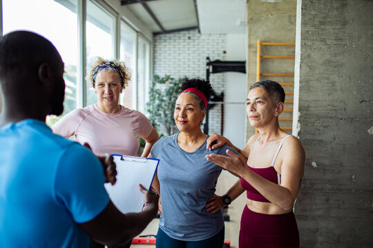 Senior women with trainer in gym