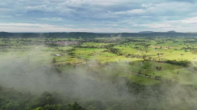 Beautiful 4K drone footage showcasing Thad Phuwong village nestled among green mountains in Waritchaphum, Sakon Nakhon, Thailand &mdash; a serene rural landscape.