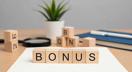 Wooden blocks spelling "bonus" on a desk with a plant and office supplies suggest financial incentives and employee motivation concepts