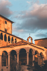 town of montona in istria, croatia, at golden hour with warm light on the small church and clouds in the sky