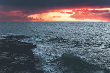 sunset over the sea in istria, croatia, with waves and dramatic purple clouds