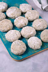 Cooking haddock fish cakes made of mince on blue cutting board. Shaping the patties