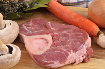 Osso bucco de veau cru avec un couteau et des ingrédients en gros plan