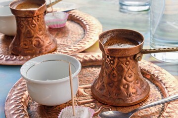 Coffee served in traditional copper cezve. Turkish coffee, arabic or bosnian coffee.