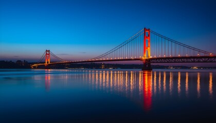 A stunning long exposure shot of a large suspension bridge illuminated with warm lights at twilight, reflecting beautifully on the calm water.