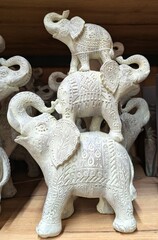 Vista de cerca de una escultura de un grupo de elefantes asiáticos con la trompa levantada en...