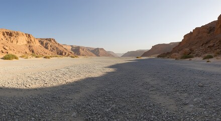 The panoramic sweep of a wide, gravel-filled wadi.