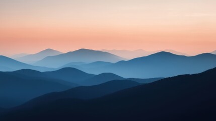 Sunset view over rolling mountain ranges with soft colors of twilight in the sky