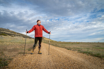senior man is Nordic walking in foothills of Rocky MOuntains in Colorado - Prairie Ridge Natural Area