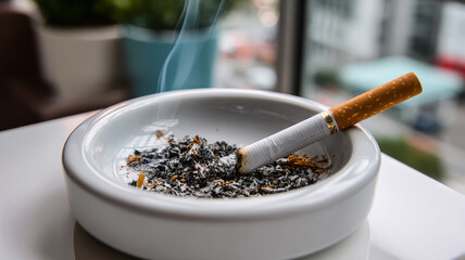 Cigarette resting in a decorative ashtray on a dark surface - Concept of worldwide day without tobacco