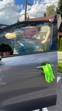 Woman cleaning car window in the parking