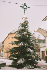 City square with decorated Christmas tree  under the snow