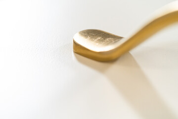 Shiny Gold Pot Handle on White Surface