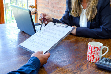 Mature adult female lawyer showing a document paper to a male client, legal contract or lawyer consulting. Disability people,  policy advice or accident report closeup