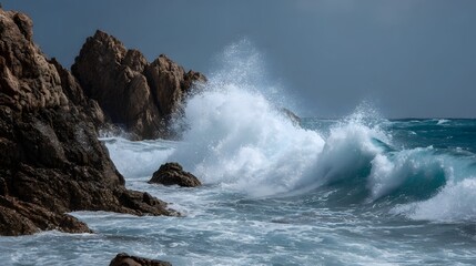 Naklejka premium Powerful ocean waves dramatically crash against rugged dark rocky cliffs under a stormy cloudy sky creating a dynamic seascape