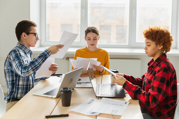 Teamwork brainstorm. Diverse colleagues working together discuss financial statistics. Group of...