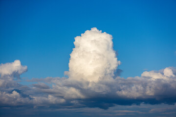 White cumulus cloud with unusual shape on blue sky for background