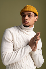 Handsome young man showcases fashionable style with a cozy turtleneck and beanie