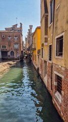 Obraz premium Narrow streets of Venice with turquoise canals and colorful buildings, scenic Italian cityscape.