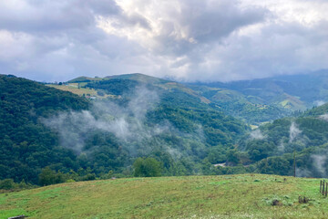 Picturesque landscapes with rolling green hills and mountains in the highlands of Cantabria, Spain.