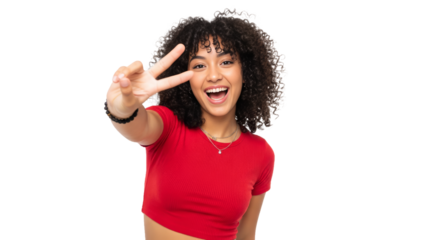 Latina teenager with curly hair shows playful spirit with a peace sign against bright background