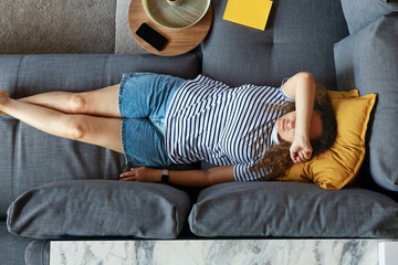 Relaxed young woman lounging on sofa
