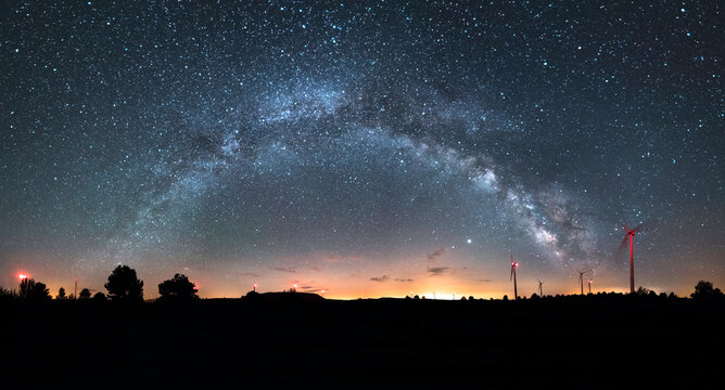 Astrophotography of the Milky Way and Windmills on a Mountain Ridge