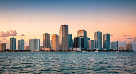 Naklejka premium Skyline of a modern city at sunset, reflected in tranquil water, with soft colors