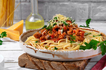 Bolognese pasta with haddock fish mince served with parmesan cheese on ceramic plate. Pescatarian meal. Variation of the classic Italian dish