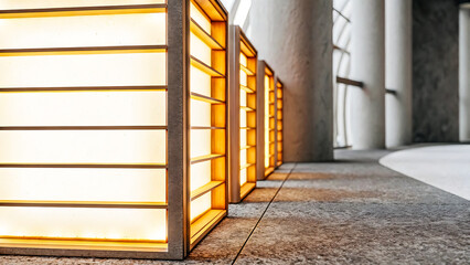Modern architectural lighting design featuring illuminated rectangular panels in a contemporary building hallway with textured flooring