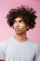 Young ethnic man with curly hair looking up