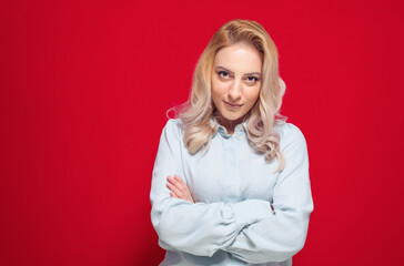 Close-up smile woman takes photo of himself with her smartphone. Selfie, isolated on red background. Focus on face