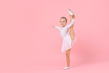 Cute little girl doing gymnastic exercise on pink background. Space for text